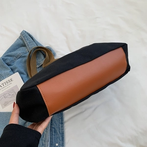 Large canvas tote bag with reinforced brown leather base and contrast stitching detail