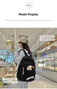 Detail of black corduroy school backpack featuring a 3D cartoon puppy and bone charm