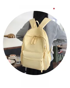 Sac à dos en nylon jaune pâle avec cordon tressé porté par un mannequin dans un café