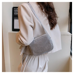 Silver rhinestone handbag for women worn over a suit for a refined and elegant banquet look
