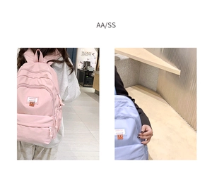 Detail of multi-compartment nylon backpack featuring cartoon patch and water bottle pocket