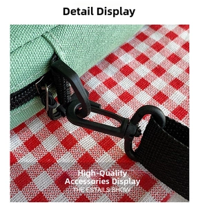 Detailaufnahme von schwarzem Reißverschluss und D-Ring-Wirbelhaken an grüner Stofftasche
