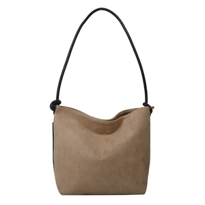 Matte finish khaki bucket bag with minimalist black knotted shoulder strap on white background