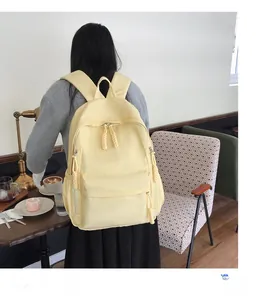 Sac à dos en nylon crème dans un café mettant en valeur les détails de la fermeture