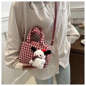 Close-up of red gingham crossbody bag with a cute plush puppy charm accessory