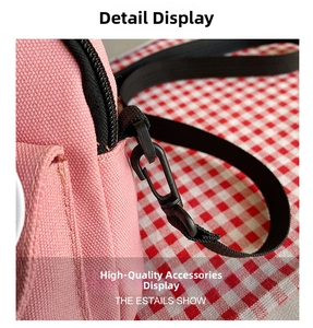 Close-up of pink canvas bag showing black nylon strap connection and durable plastic buckle