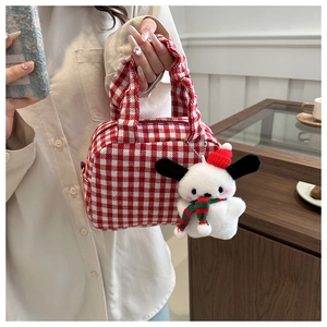 Detail of red and white checkered canvas bag with a cute plush puppy charm accessory