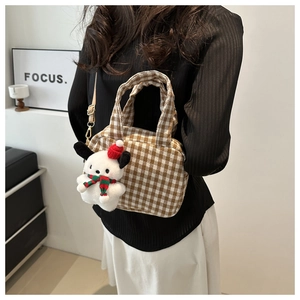 Detail view of brown checkered plaid bowling bag with cute plush puppy charm on strap