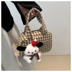 Detail of brown plaid canvas bowling bag featuring a plush dog charm with festive scarf
