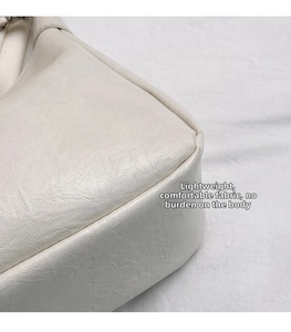 Detailed macro view of cream tote bag showing fine lychee leather texture and stitching