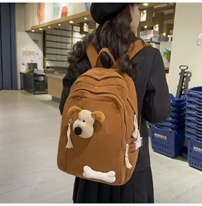 Detailed close-up of brown corduroy backpack with puppy and bone character 3D decorations