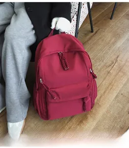 Sac à dos imperméable bordeaux en nylon avec tissu texturé et tirettes tressées