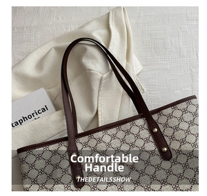 Close-up of retro tote bag featuring clover pattern and brown leather handles with gold studs