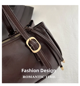 Detailed close-up of dark brown leather handbag with gold-tone hardware and fine stitching