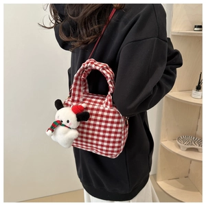 Detail of red checkered canvas bowling bag with soft pleated handle and plush dog charm
