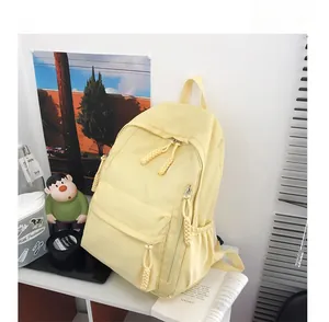 Détail d'un sac à dos en nylon jaune vif avec tirettes tissées et poche frontale zippée