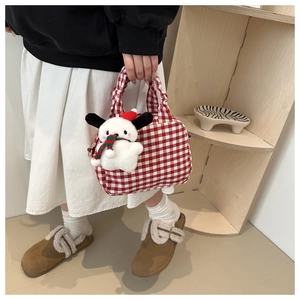 Detail of red and white plaid canvas bag with cute plush dog charm in Christmas theme