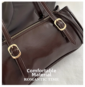 Detail of dark brown vintage handbag with shiny finish and gold adjustable buckles
