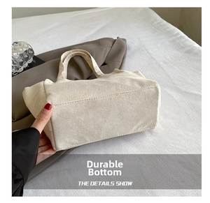 Detail shot of the reinforced wear-resistant base on a beige corduroy mini tote bag