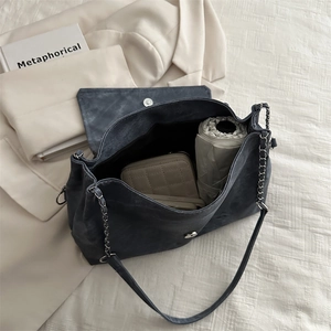 Blue matte tote bag with silver chain strap showcasing spacious commute interior