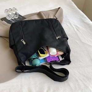 Black high-capacity canvas messenger bag shown with daily essentials and thick strap