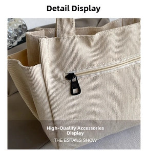 Detail view of cream corduroy fabric texture and durable black metal zipper closure