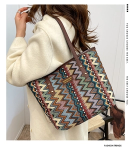 Close-up of woven ethnic tote bag with geometric patterns and brown leather straps