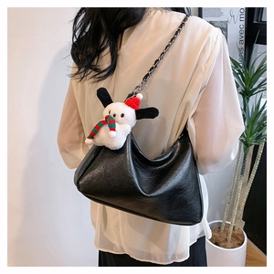 Detail view of black PU leather crossbody bag with silver chain strap and plush puppy charm