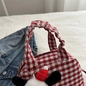 Red gingham canvas handbag with ruffled handle and cute plush charm in close-up view