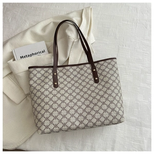 Detailed top view of retro tote bag with brown geometric patterns and golden metal rivets