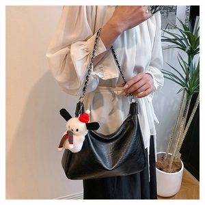 Detail of black pleated hobo bag with silver chain strap and festive puppy charm