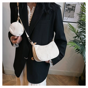 Détail du sac croissant en velours côtelé blanc cassé avec chaîne et petit porte-monnaie