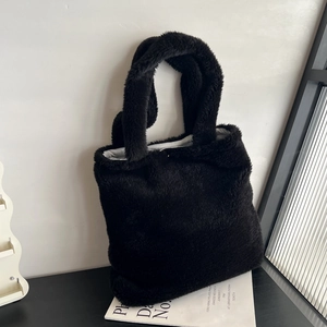 Close-up of black faux fur tote bag showing soft texture on a minimalist background