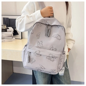 Macro detail of lavender butterfly print backpack with woven zipper pull and side pockets