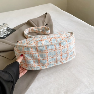 Blue and orange plaid corduroy crossbody dumpling bag on a soft white background