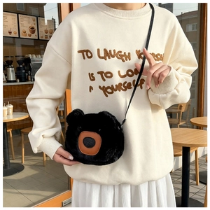Detail of cute black plush bear crossbody bag with soft faux fur and leather nose accent
