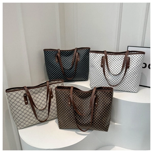 Geometric printed tote bags collection in four colors displayed on a modern pedestal