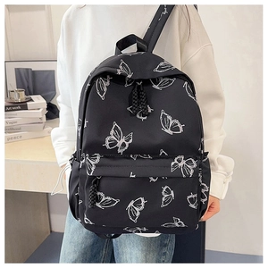 Close-up of lightweight black backpack featuring white butterfly prints and zip pockets