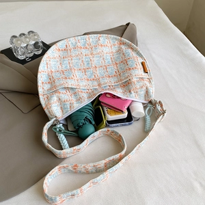 Blue and orange checkered corduroy dumpling bag showing large storage capacity