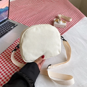 Japanese style cream canvas crossbody bag with adjustable strap and saddle shape design