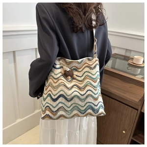 Dettaglio della borsa a secchiello in lana intrecciata con motivo chevron colorato