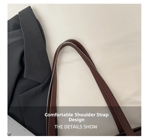Detail of the brown leather strap with double stitching on a black blazer background