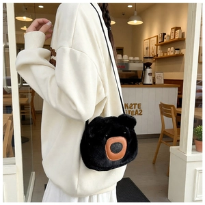 Close-up of a cute black fuzzy bear crossbody bag featuring brown leather details