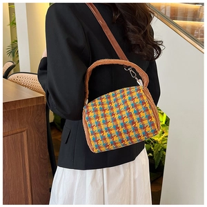 Detail of a vintage plaid crossbody bag featuring multi-color tweed and plush brown trim