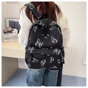 Detailed back view of a black backpack with white butterfly prints for student use