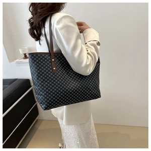 Detail of retro printed tote bag featuring geometric patterns and brown leather strap