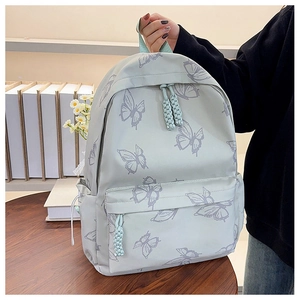 Detail of mint green backpack featuring purple butterfly prints and woven zip pullers