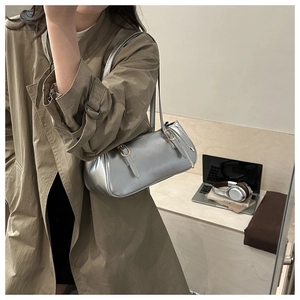 Detail of silver baguette bag with metallic leather and gold buckle in a workplace setting