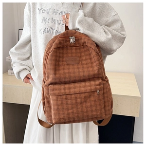 Detailed texture of caramel brown corduroy backpack with classic checkered pattern