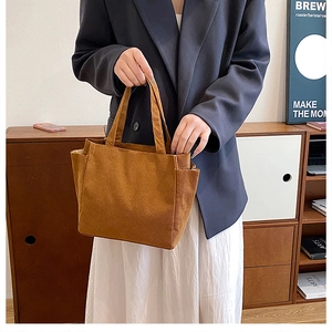 Close-up of brown corduroy tote bag with side pockets and sturdy top handles